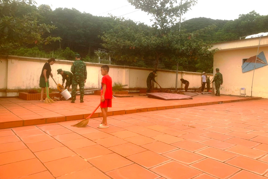 Người dân và các bộ chiến sỹ dọn dẹp khuôn viên trường.