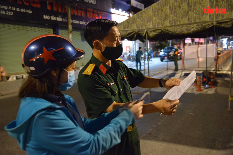 Người dân xuất trình giấy tờ tùy nhân và giấy xác nhận nơi làm việc của công ty cho cơ quan chức năng kiểm tra nếu muốn vào bên trong quận Gò Vấp.