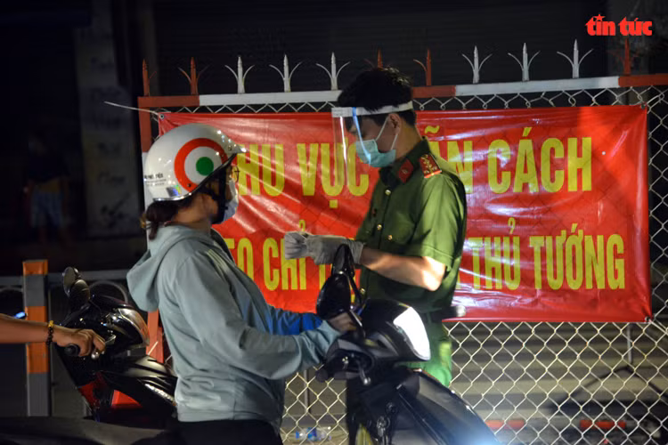 Người dân xuất trình giấy tờ tùy thân cho lực lượng chức năng kiểm tra trước khi ra khỏi địa bàn quận Gò Vấp.