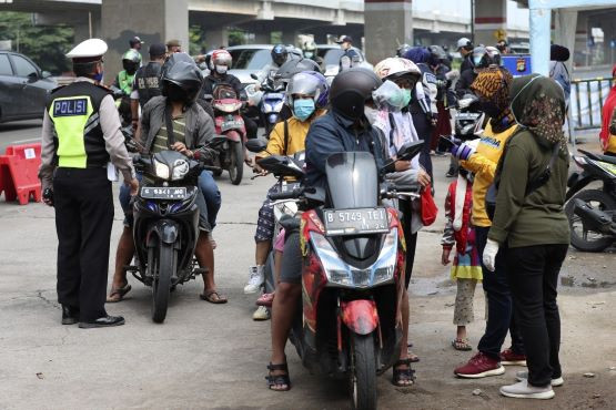 Cảnh sát Indonesia sàng lọc người lái xe tại một trạm kiểm soát dịch COVID-19 ở ngoại ô Jakarta. Ảnh: AP Cảnh sát Indonesia sàng lọc người lái xe tại một trạm kiểm soát dịch COVID-19 ở ngoại ô Jakarta. Ảnh: AP