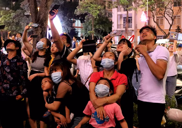 Mọi người hướng về phía sân khấu chính để theo dõi những quả pháo hoa bắn lên cao.