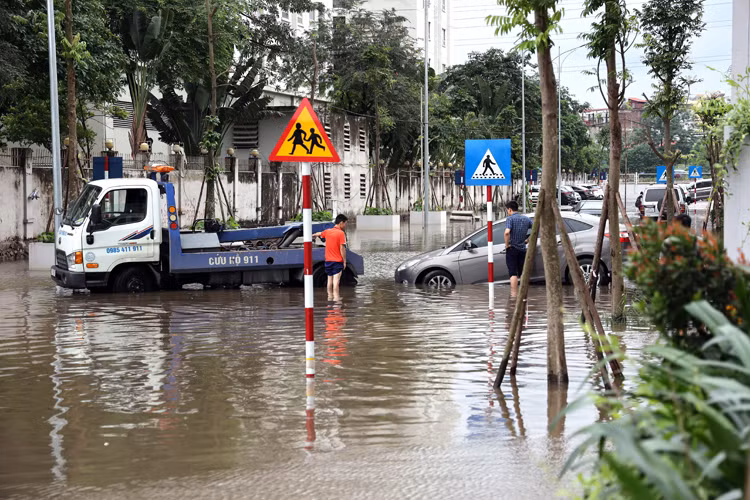 Xe cứu hộ kéo một chiếc xe ô tô ra khỏi khu vực bị ngập.