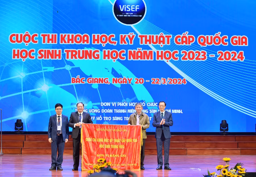 Lãnh đạo Sở GD&ĐT Bắc Giang (bên trái) trao cờ cho lãnh đạo Sở GD&ĐT TP Hồ Chí Minh, đơn vị đăng cai năm tiếp theo.