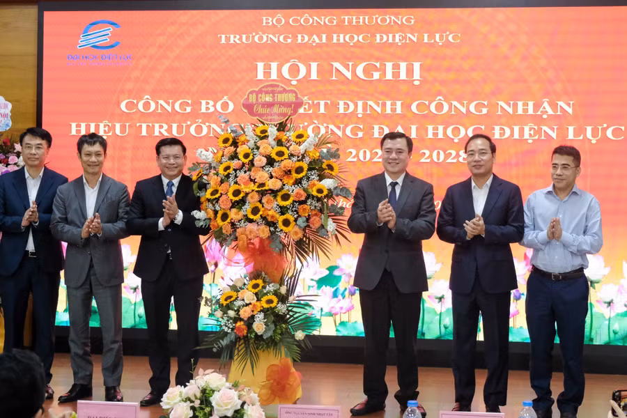 Thứ trưởng Bộ Công Thương Nguyễn Sinh Nhật Tân và đại biểu chúc mừng tân Hiệu trưởng Trường Đại học Điện lực.