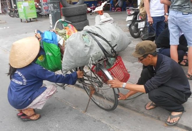 Người đàn ông bơm vá xe miễn phí cho HSSV và người tàn tật 