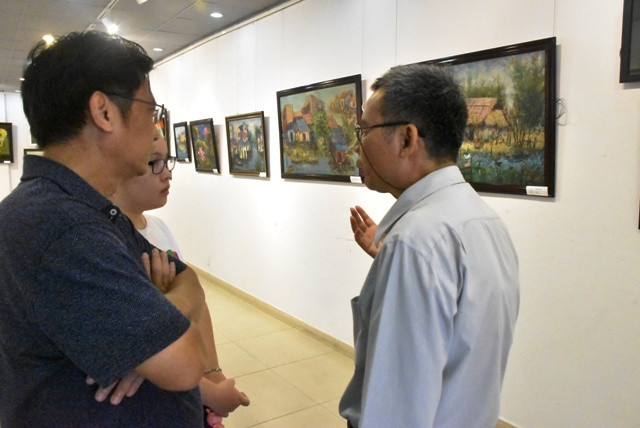 Họa sĩ Vũ Xuân Hương (bìa phải) trao đổi cùng một số phụ huynh và HS tại triển lãm Họa sĩ Vũ Xuân Hương (bìa phải) trao đổi cùng một số phụ huynh và HS tại triển lãm