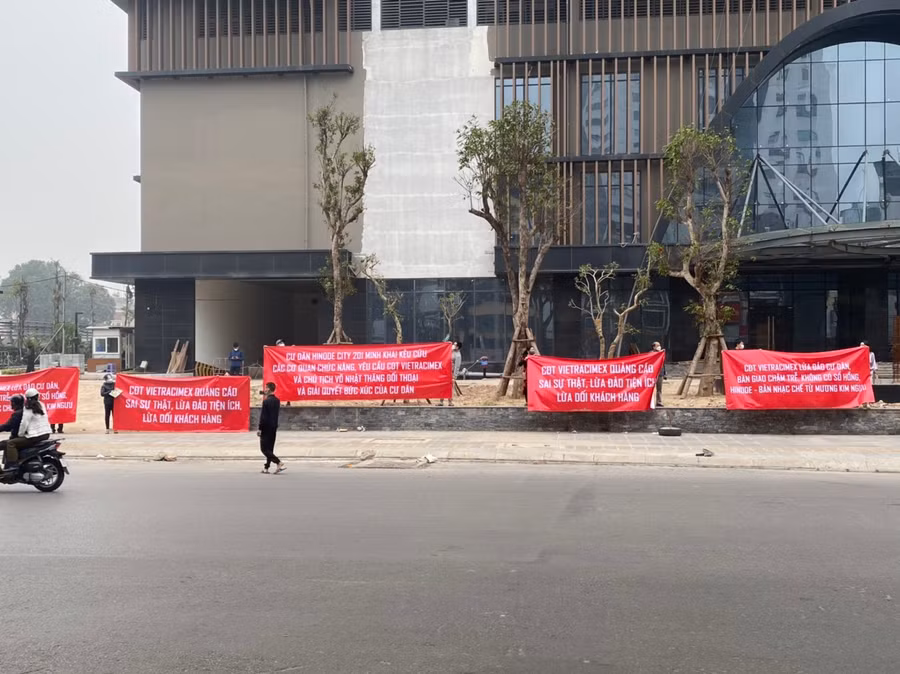 Nhiều cư dân Hinode cầm băng rôn đứng trước sảnh chung cư.