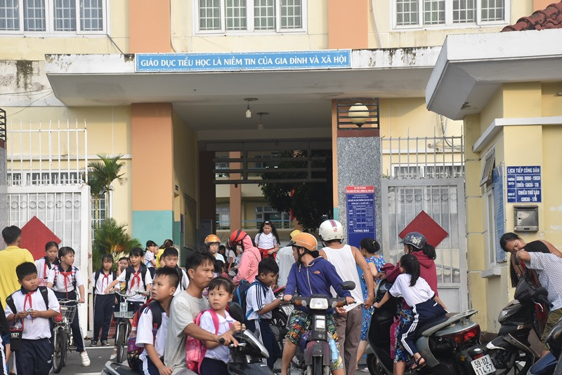 Phụ huynh học sinh Trường tiểu học Lưu Hữu Phước, nhanh chóng đưa con rời trường trước khi triều lên.