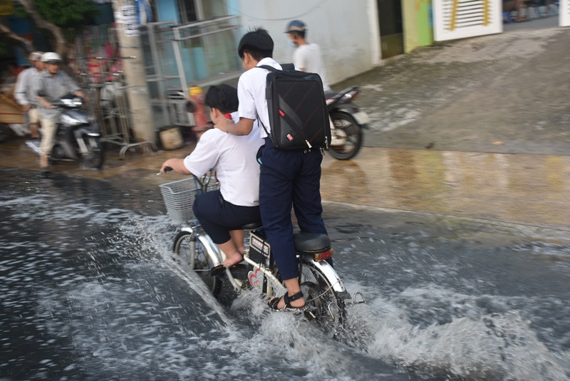 "Làm xiếc" nguy hiểm giữa "biển" nước triều cường.