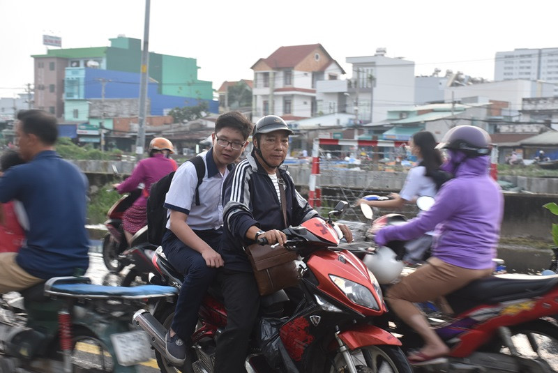 Một phụ huynh phải chở con quay ngược lại do triều ngập sâu.