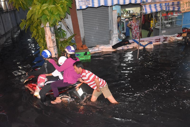 Một phụ huynh phải nhờ người dân xung quanh đẩy xe vì chết máy.