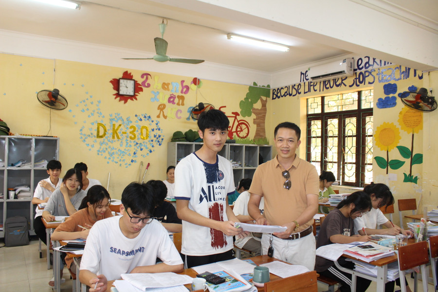 Thầy Trần Quốc Lập trao đổi bài với học sinh lớp ôn tập. Thầy Trần Quốc Lập trao đổi bài với học sinh lớp ôn tập.