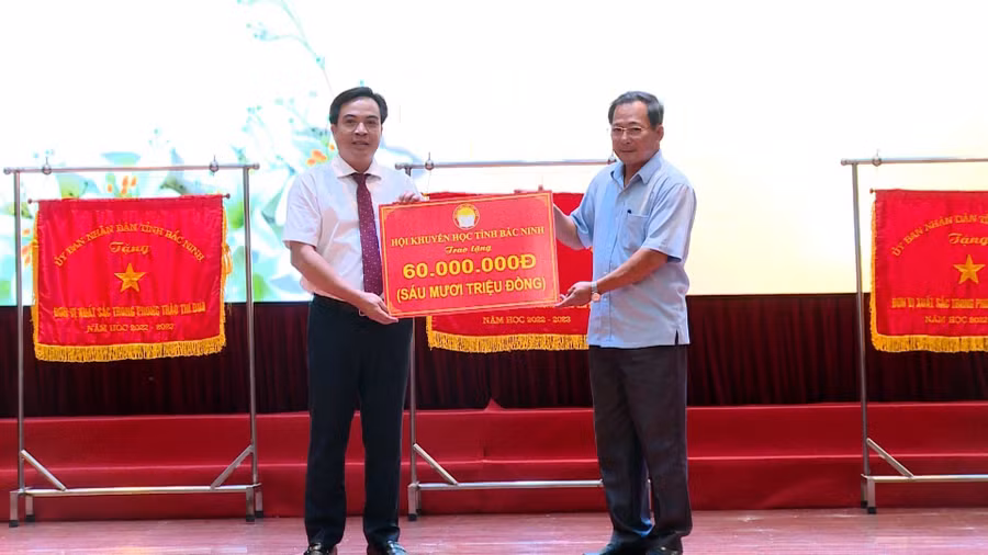 Ông Trịnh Văn Điền (bên phải) - Chủ tịch Hội Khuyến học tỉnh Bắc Ninh trao học bổng gửi đến học sinh có hoàn cảnh khó khăn trên địa bàn thành phố.