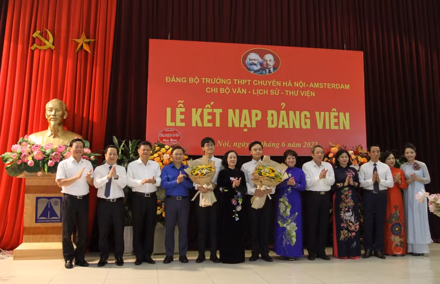 Đồng chí Trương Thị Mai tặng hoa chúc mừng hai đảng viên mới và Đảng bộ nhà trường