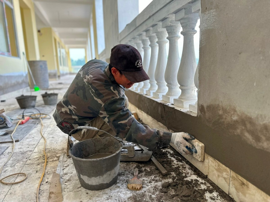 Nhóm công nhân đang trát những phần còn lại của khối nhà học số 1.