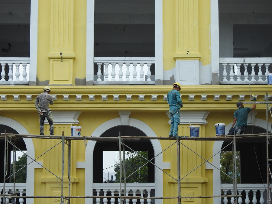 Nhóm công nhân tiến hành sơn mặt trước của trường học.