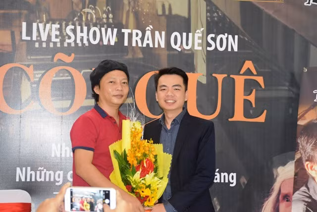 Đại diện đơn vị hỗ trợ tặng hoa chúc mừng nhac sĩ Trần Quế Sơn