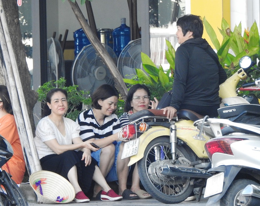 Một số phụ huynh tìm gốc cây có bóng mát đợi con.