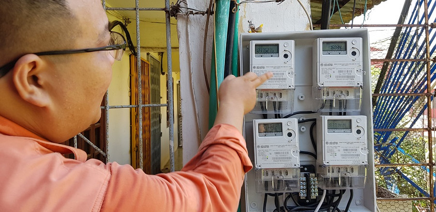 Nhân viên Điện lực Đống Đa đang giải thích cho khách hàng vì sao cắt hết nguồn điện mà công tơ vẫn chạy.