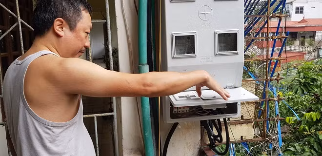 Anh Nguyễn Đình Thi đang loay hoay tìm công tơ điện nhà mình.