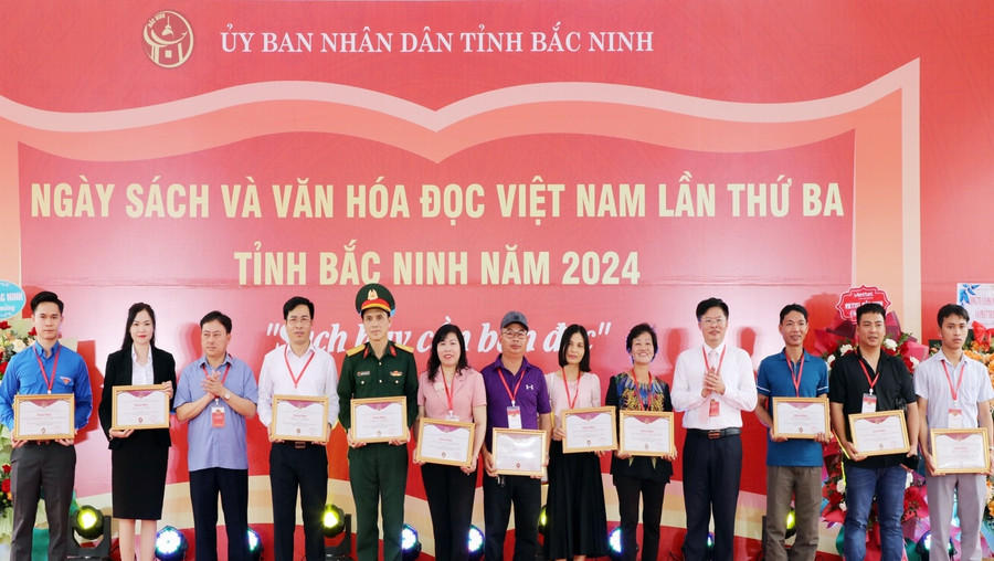 Giám đốc Sở TT&amp;TT Bắc Ninh - Nguyễn Trung Hiền (thứ 4 từ phải qua) và Phó Chánh Văn phòng UBND tỉnh Ngô Văn Luyến trao tặng Giấy chứng nhận cho các đơn vị, nhà sách tham gia trưng bày sách.