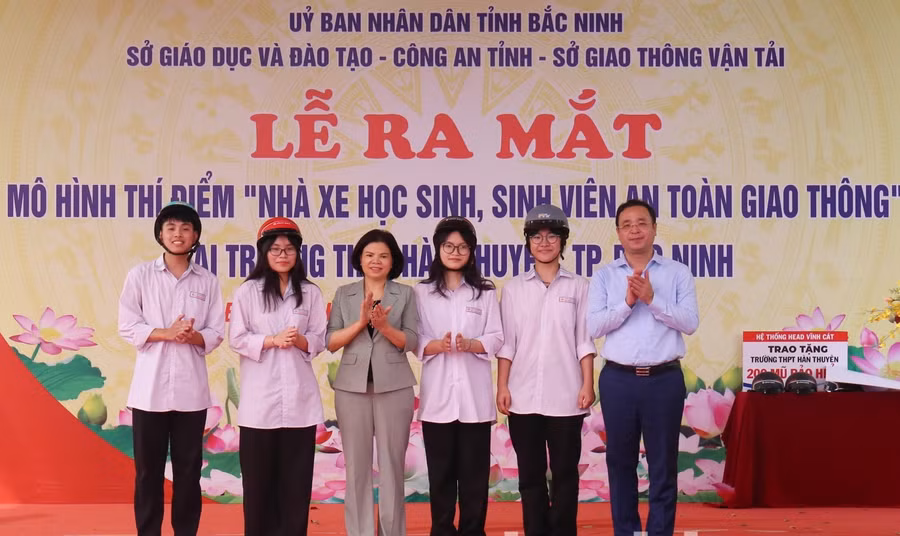 Chủ tịch UBND tỉnh Bắc Ninh - Nguyễn Hương Giang và Giám đốc Sở GDĐT Bắc Ninh Nguyễn Thế Sơn trao mũ bảo hiểm cho học sinh.