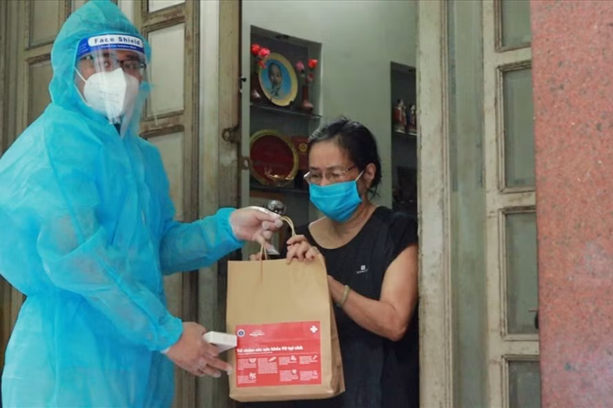 Bệnh nhân F0 điều trị tại nhà được phát thuốc. Ảnh LDO.