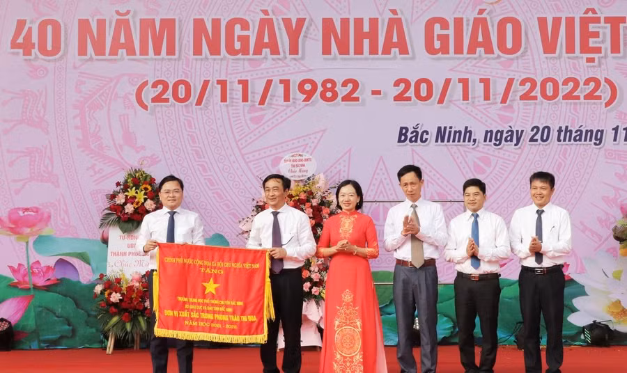 Thừa ủy quyền, Bí thư Tỉnh ủy Bắc Ninh - Nguyễn Anh Tuấn (ngoài cùng bên trái) trao Cờ thi đau của Chính phủ cho Trường THPT Chuyên Bắc Ninh.