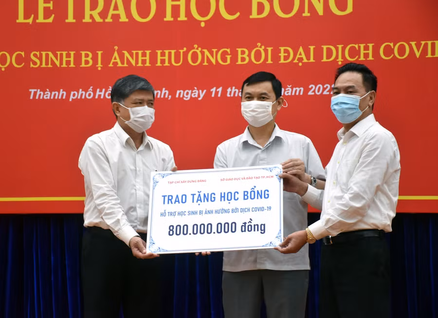 Doanh nhân Nguyễn Hoài Bắc (bìa phải và ông Ngô Minh Tuấn (Tổng Biên tập Tạp chí Xây dựng Đảng, giữa) trao biểu trưng học bổng cho Giám đốc Sở GD&amp;ĐT TPHCM