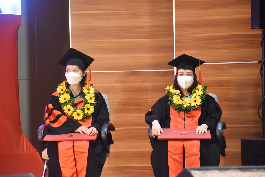 Hai nghiên cứu sinh nhận bằng Tiến sĩ tại buổi lễ.