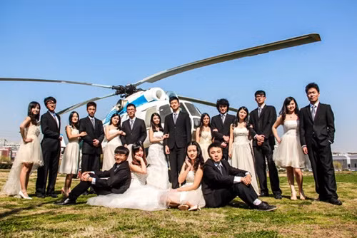 Tại Đại học Hàng không và Vũ trụ Nam Kinh, các sinh viên chụp ảnh cùng máy bay và trực thăng. Ảnh:WSJ At the Nanjing University of Aeronautics and Astronautics, graduates posed with on-campus airplanes and helicopters in wedding regalia earlier this year. Fan Xinxin