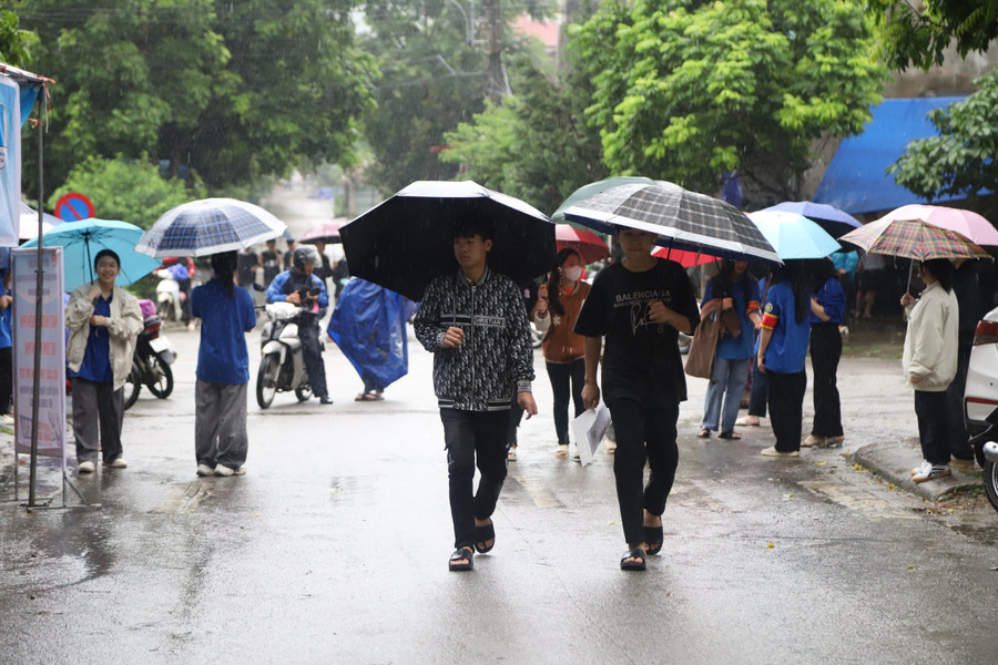 Cô Hoàng Thị Thu Hương - giáo viên Trường Phổ thông DTBT Hoà Bình chia sẻ: &quot;Tôi đảm nhận đưa trò đi đến điểm thi và đón về trong suốt kỳ thi. Mưa lớn khiến cô trò khá vất vả, nhưng tôi luôn động viên học trò vất vả hôm nay là thành công của mai sau. Trong buổi thi đầu tiên, tôi mong rằng các em sẽ làm bài thi tốt để tự tin, bình tĩnh hoàn thành kỳ thi một cách tốt nhất&quot;. Ảnh NC.