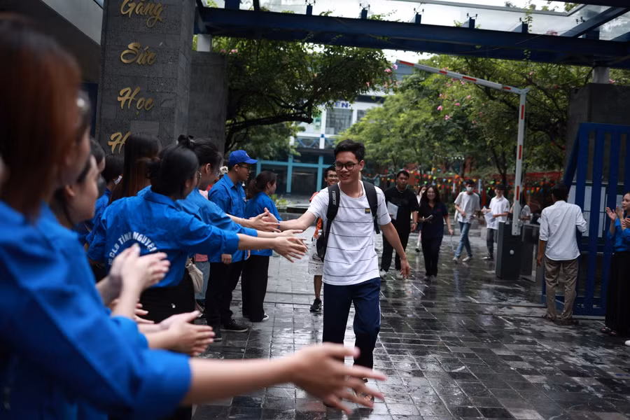 Tại điểm thi Trường THCS&amp;THPT Lương Thế Vinh (Cầu Giấy, Hà Nội), trước khi hết giờ, đội thành niên tình nguyện đã chờ sẵn ở cổng gửi lời chúc mừng đến các thí sinh hoàn thành môn thi đầu tiên.