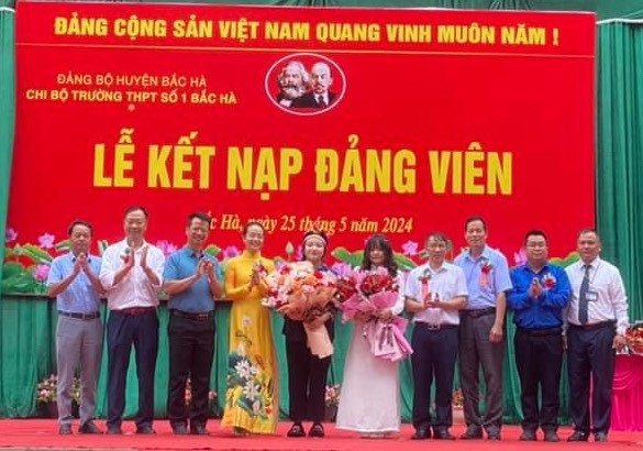 Phạm Khánh Ly (học sinh lớp 12A1, dân tộc Phù Lá) và Đoàn Quỳnh Trang (học sinh lớp 12A1, dân tộc Kinh) trong Lễ kết nạp Đảng.