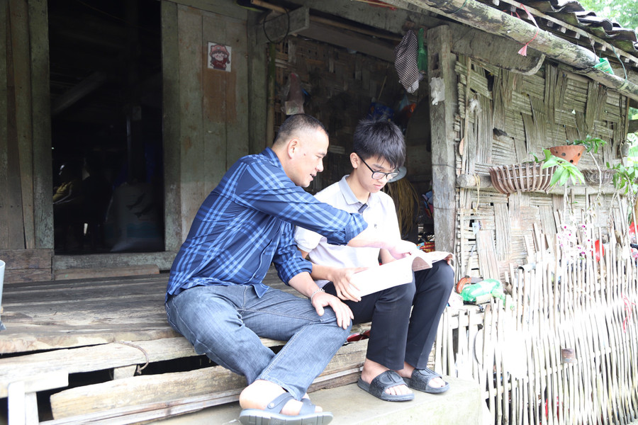 Đến nhà trò trời vẫn mưa, thầy Hà Văn Diễn – giáo viên Trường Tiểu học và THCS 1 An Sơn tranh thủ ôn lại bài cùng học sinh. Ảnh NC.