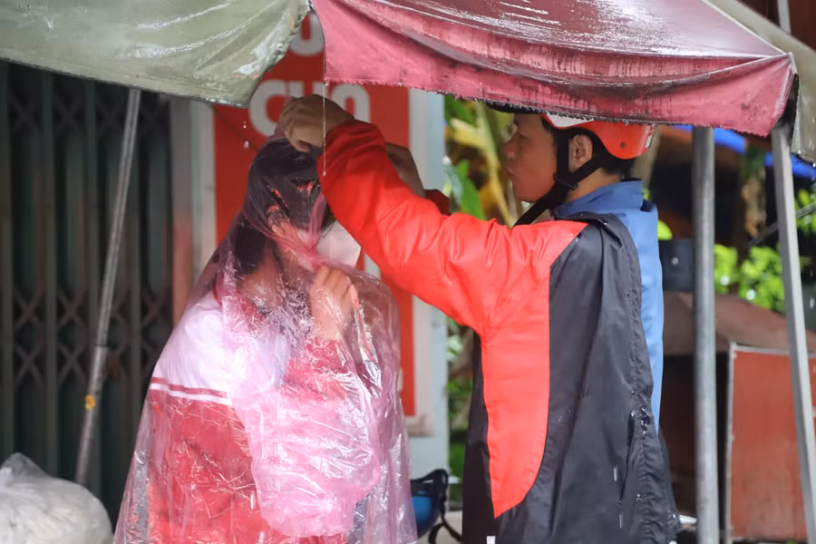 Trời mưa lớn, nhiều thí sinh được phụ huynh đưa đến trường thi từ rất sớm. Ảnh NC.