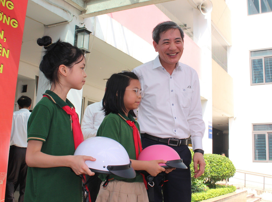 Ông Hoàng Minh Dũng Tiến - Bí thư Quận ủy Ba Đình tặng mũ bảo hiểm cho các em học sinh.