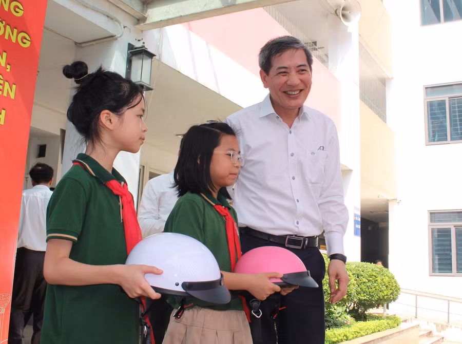 Ông Hoàng Minh Dũng Tiến - Bí thư Quận ủy Ba Đình tặng mũ bảo hiểm cho các em học sinh.
