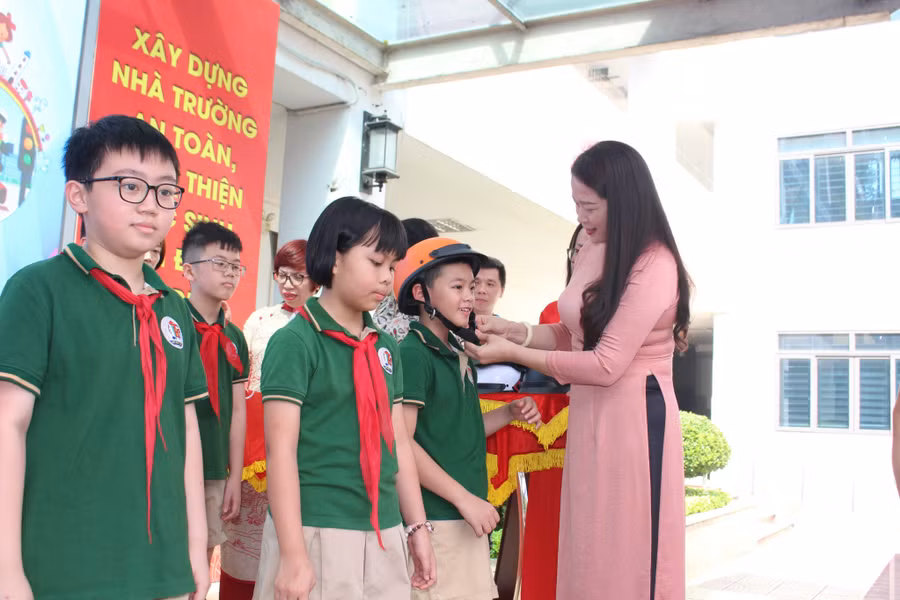 Phó Chủ tịch UBND quận Ba Đình - Phạm Thị Diễm tặng mũ bảo hiểm cho học sinh.