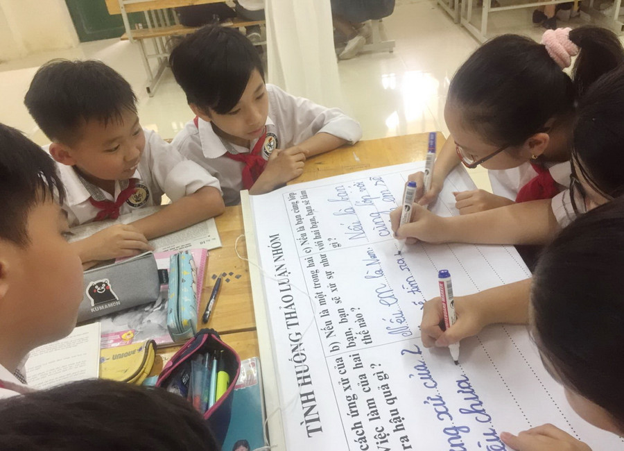 Học sinh thảo luận nhóm trong giờ học môn đạo đức.