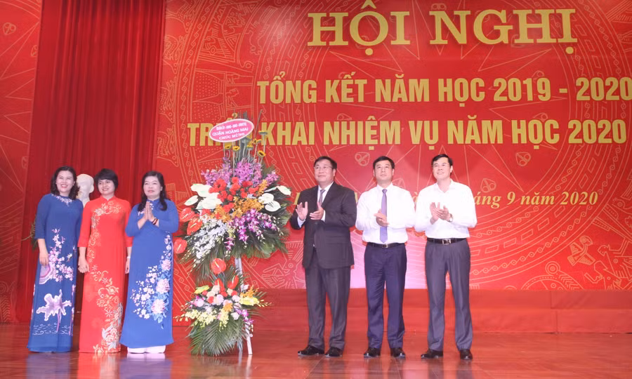 Lãnh đạo quận Hoàng Mai tặng hoa chúc mừng đại diện ngành Giáo dục quận.