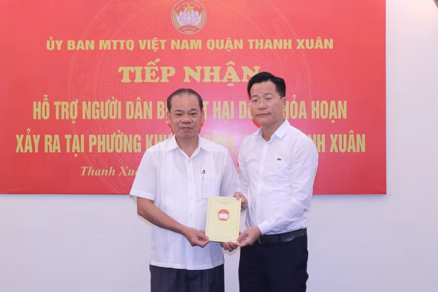 Đại diện quận Ba Đình trao quà của Hội Đông y quận Ba Đình gửi tới gia đình nạn nhân vụ hỏa hoạn.