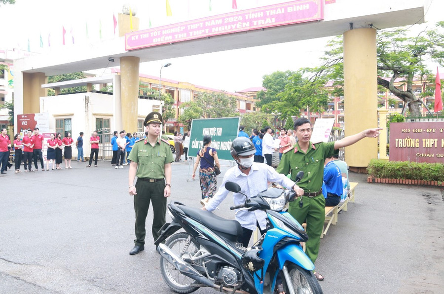 Tại điểm thi Trường THPT Nguyễn Trãi, CSGT và sinh viên tình nguyện cùng tham gia điều tiết giao thông tại khu vực cổng trường.