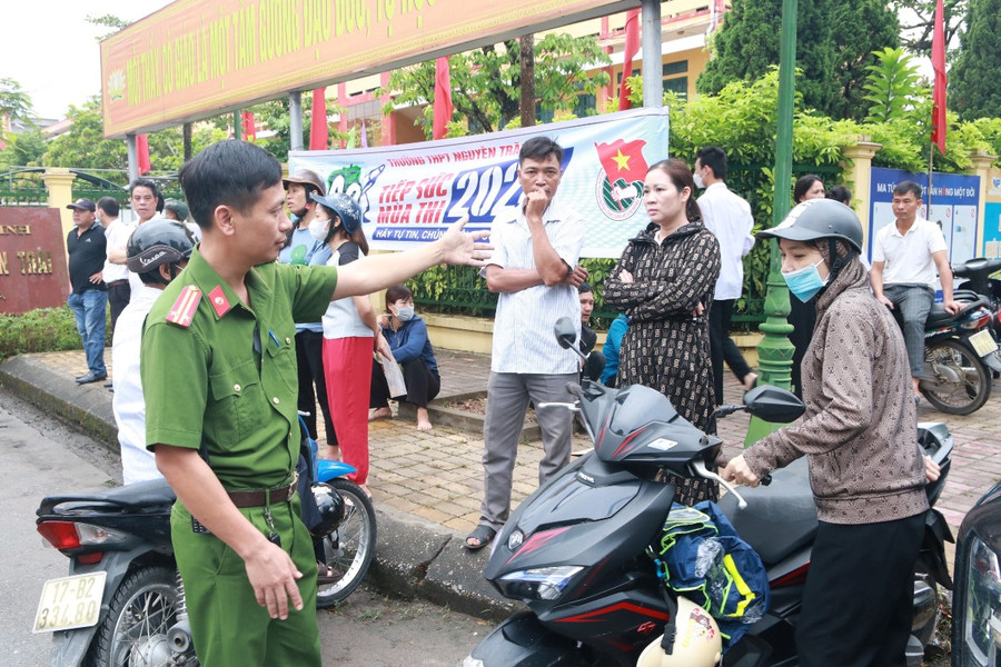 Lực lượng an ninh nhắc nhở, hướng dẫn người nhà thí sinh để xe đúng nơi quy định.