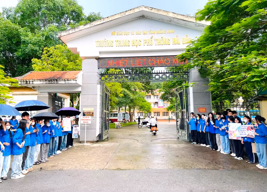 Tại điểm thi Trường THPT Hải Đảo, huyện Vân Đồn, các tình nguyện viên đứng 2 bên cổ vũ các thí sinh.