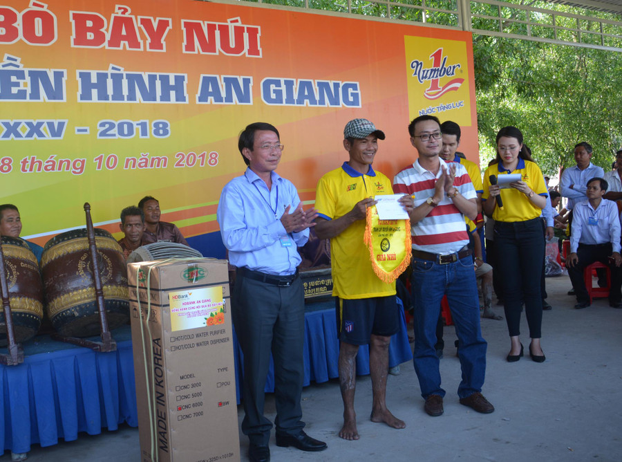 Ông Lê Nguyễn Đức Khôi, Trưởng phòng Quan hệ Công chúng, Tập đoàn Tân Hiệp Phát (bên phải) và Nhà báo Phạm Trung Lương, Phó giám đốc Đài Phát thanh Truyền hình An Giang trao giải Nhì cho ông Ngô Văn Cước ở xã Núi Voi, huyện Tịnh Biên, An Giang với số tiền thưởng 20 triệu đồng