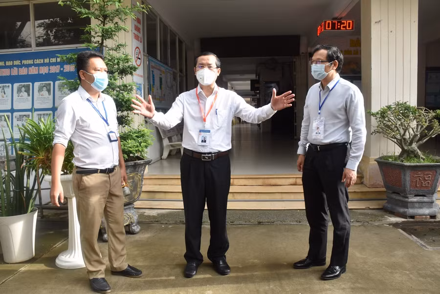 Thứ trưởng Nguyễn Văn Phúc (giữa) trao đổi với ông Lê Hoài Nam - Phó Giám đốc Sở GD&amp;ĐT TPHCM và ông Phương Thanh Vũ - Phó điểm thi Trường THPT Giồng Ông Tố (TP Thủ Đức).