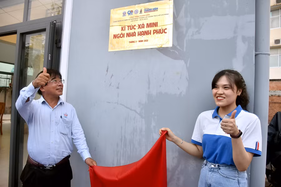 PGS.TS Đỗ Văn Dũng và nữ sinh viên Đỗ Thanh Mai kéo tấm vải đỏ khai trương bảng hiệu KTX.