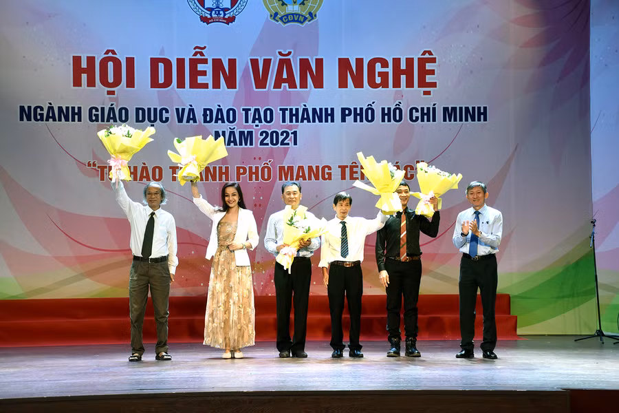 Ông Dương Trí Dũng - Phó GĐ Sở GD&amp;ĐT TPHCM tặng hoa cám ơn các thành viên Ban giám khảo của Hội diễn. Ảnh: C.Chương