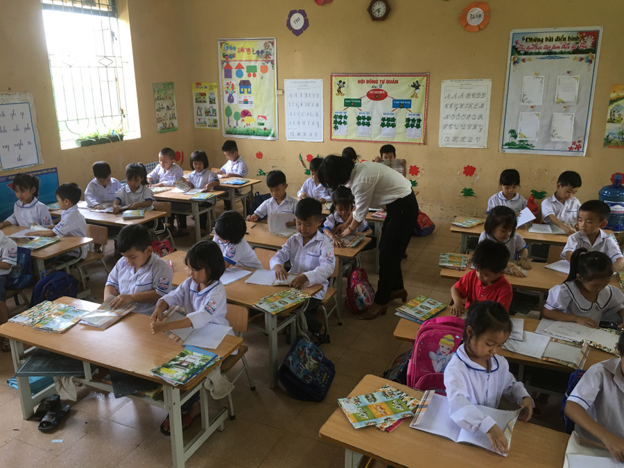 Cô giáo hướng dẫn học sinh lớp 1D bọc vở bằng bìa Cô giáo hướng dẫn học sinh lớp 1D bọc vở bằng bìa